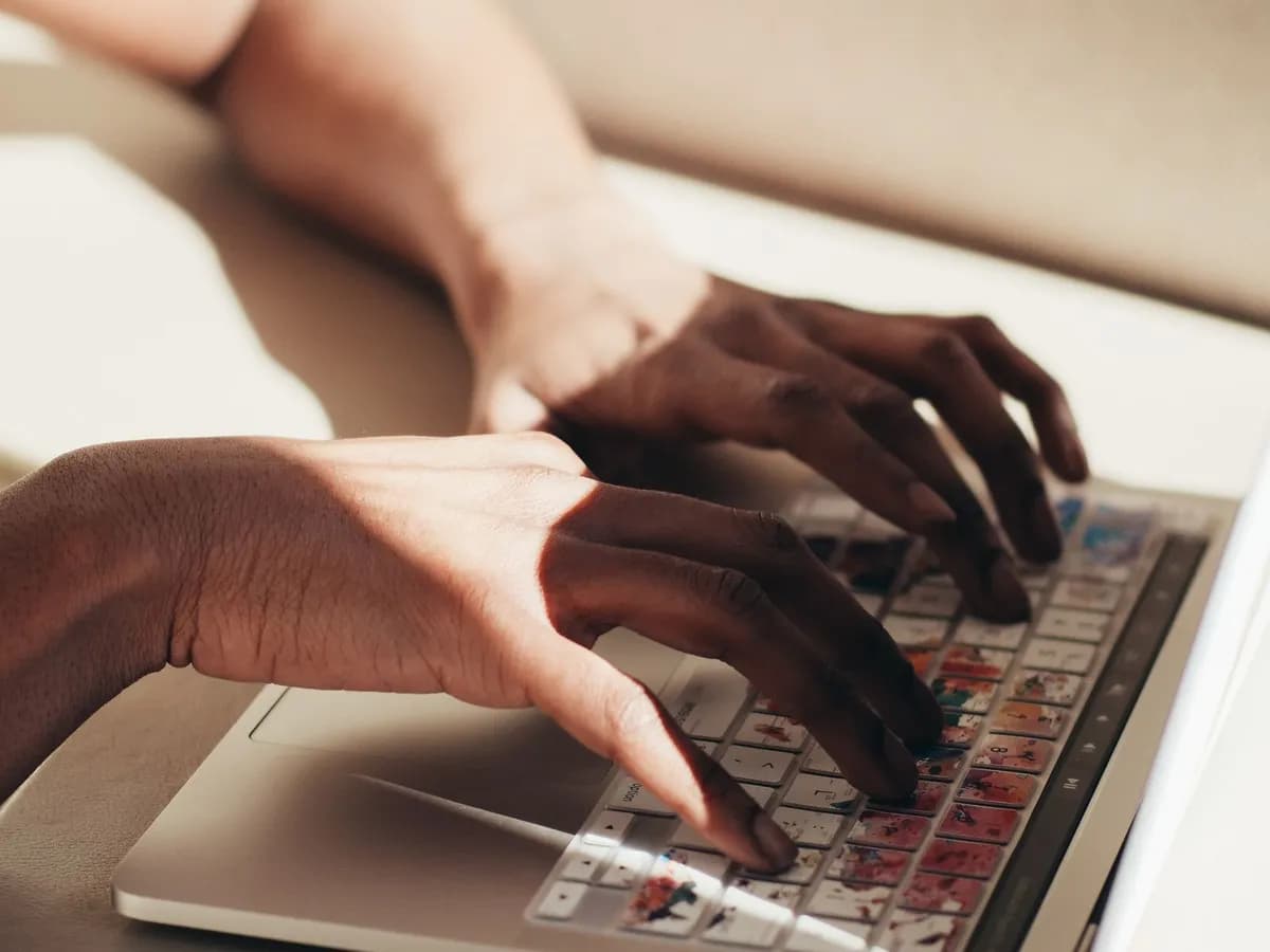 Manos escribiendo en el teclado de una laptop